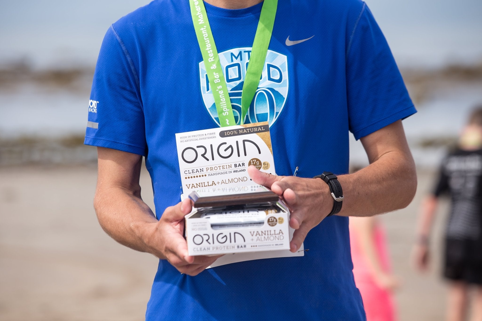 Runner holding a box of Origin protein bars at the Brandon Bay half marathon