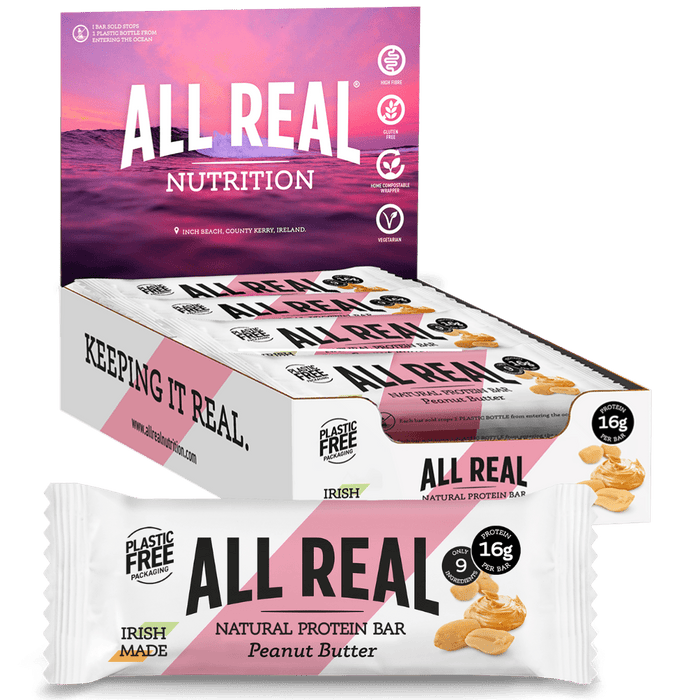 Packaging of All Real Nutrition's Peanut Butter Protein Bars. The packaging is predominantly white with pink accents, featuring images of the protein bars and peanuts.