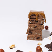All Real chocolate hazelnut protein bar stack with hazelnuts