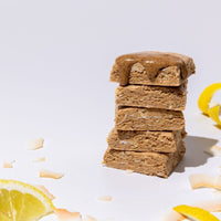 All Real lemon coconut protein bar stack with lemon and coconut