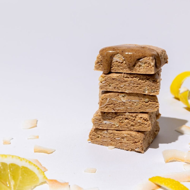 All Real lemon coconut protein bar stack with lemon and coconut