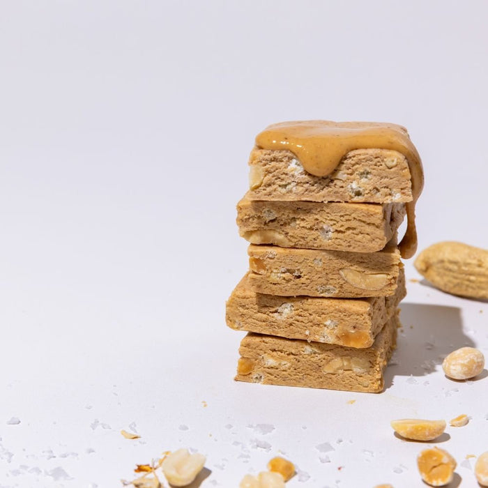 Peanut butter All Real protein bar stacked with peanut butter drizzle